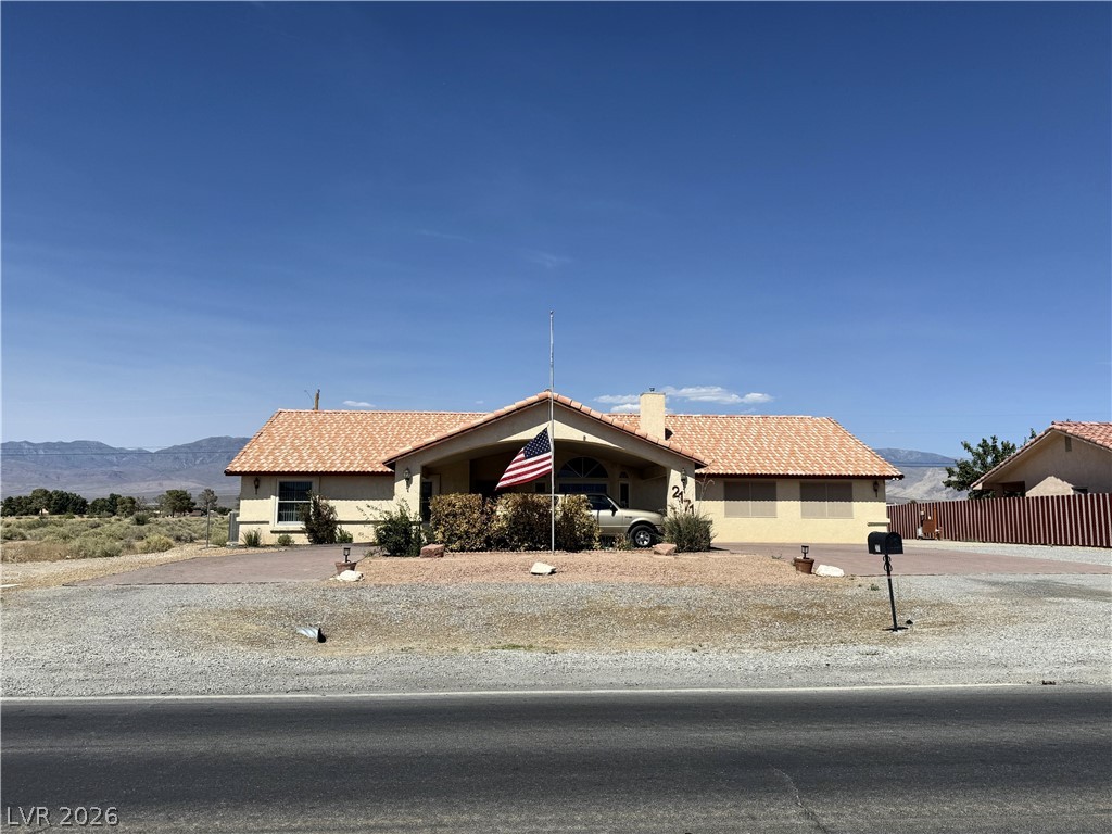 2171 South Blagg Road Pahrump, NV 89048 - Photo 2 of 27 A terracotta tile roof accents this welcoming home set against a desert mountain backdrop.