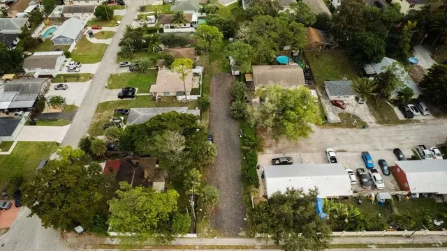 an aerial view of a residential apartment building with a yard and parking spaces