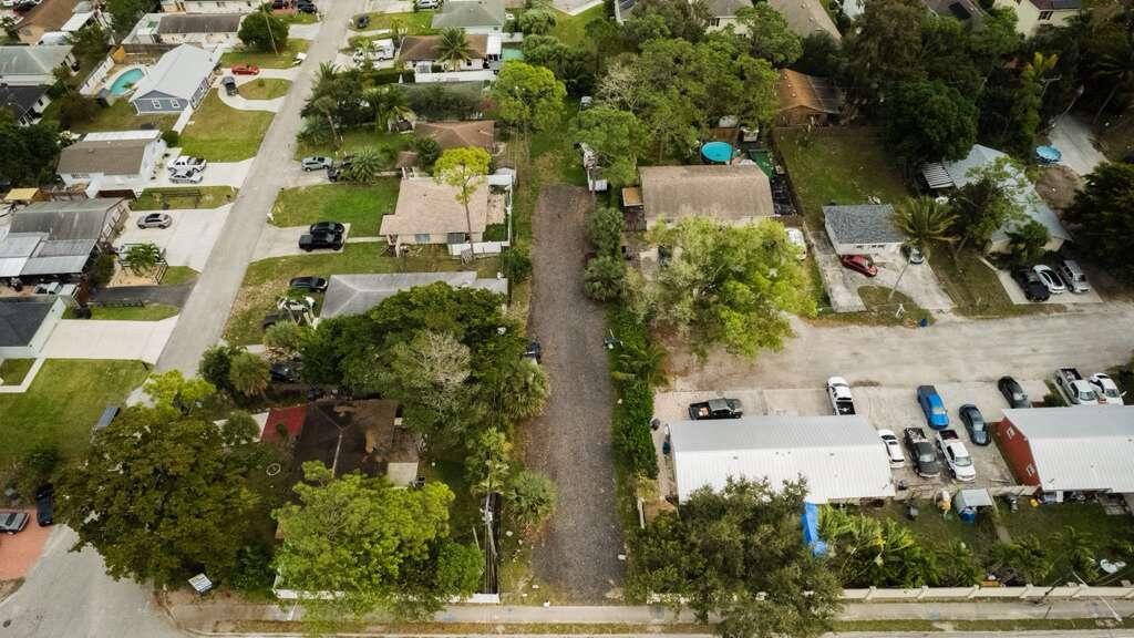 an aerial view of a residential apartment building with a yard and parking spaces