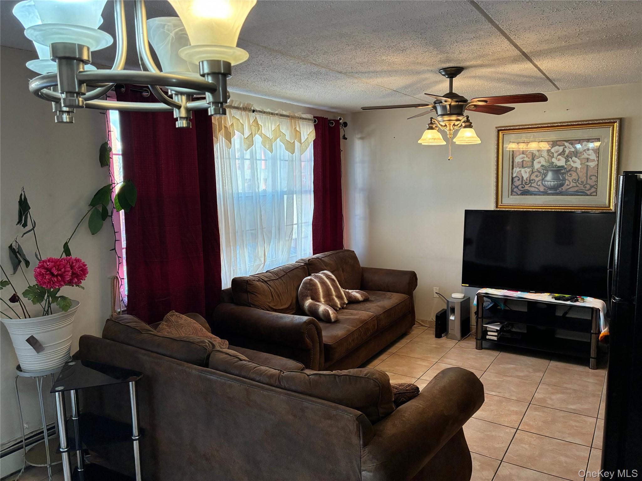 21 Renaissance Court Brooklyn, NY 11206 - Photo 2 of 21 a living room with furniture and a flat screen tv