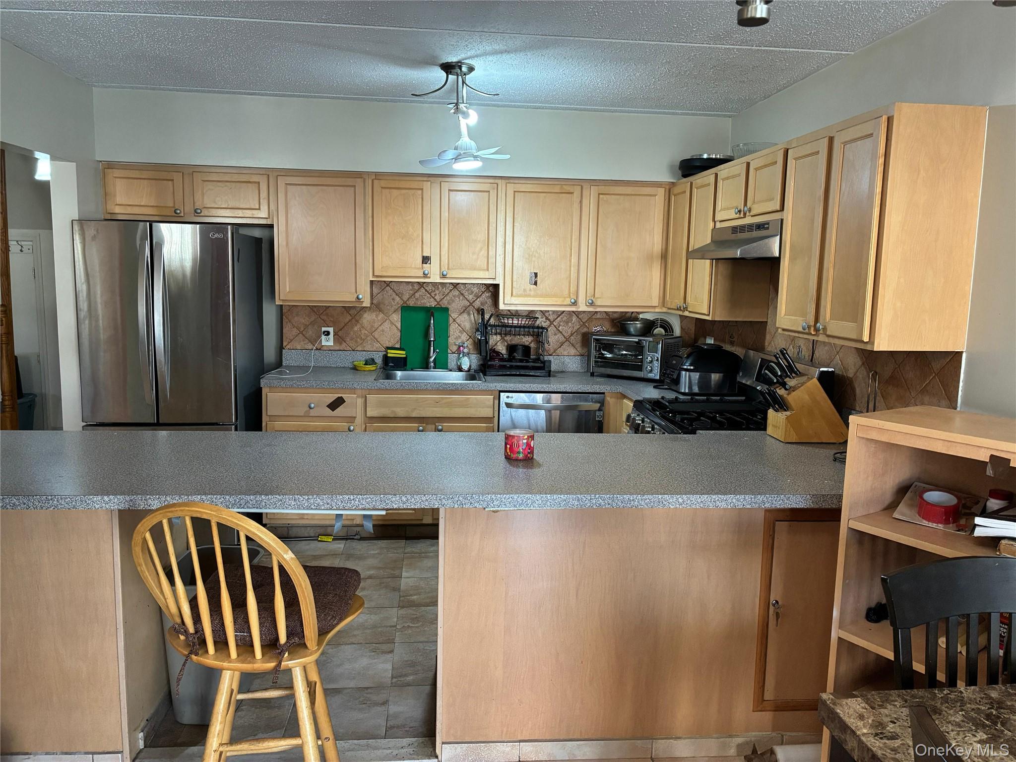 21 Renaissance Court Brooklyn, NY 11206 - Photo 5 of 21 a kitchen with kitchen island a stove a sink and a refrigerator