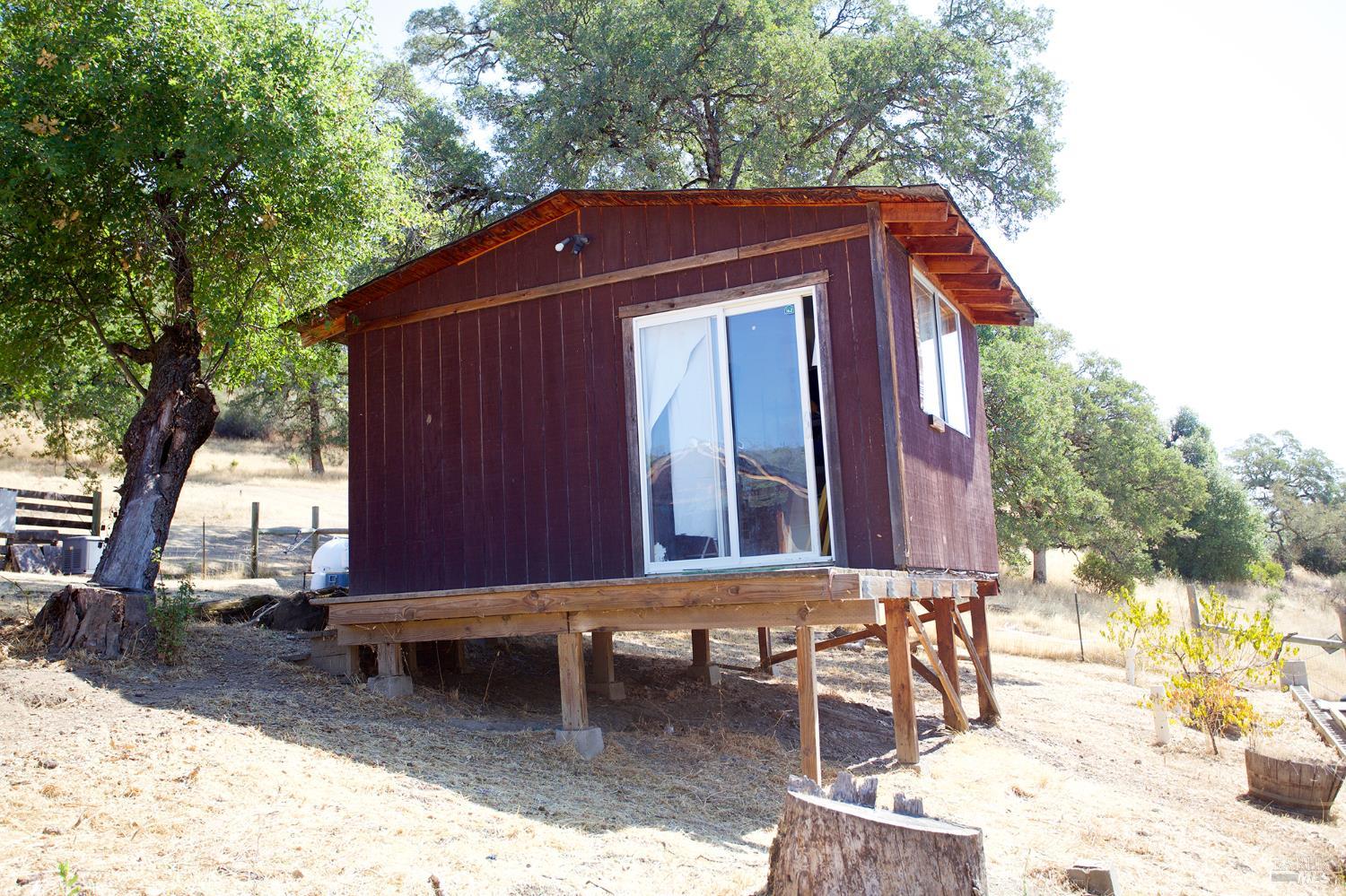 35100 Mendocino Pass Road Covelo, CA 95428 - Photo 11 of 14 a front view of a house with a yard chairs and table in the patio