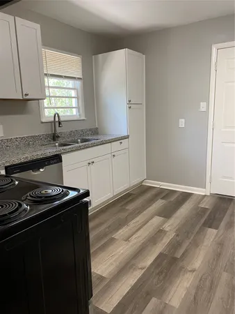 a kitchen with granite countertop cabinets stainless steel appliances a sink and a window