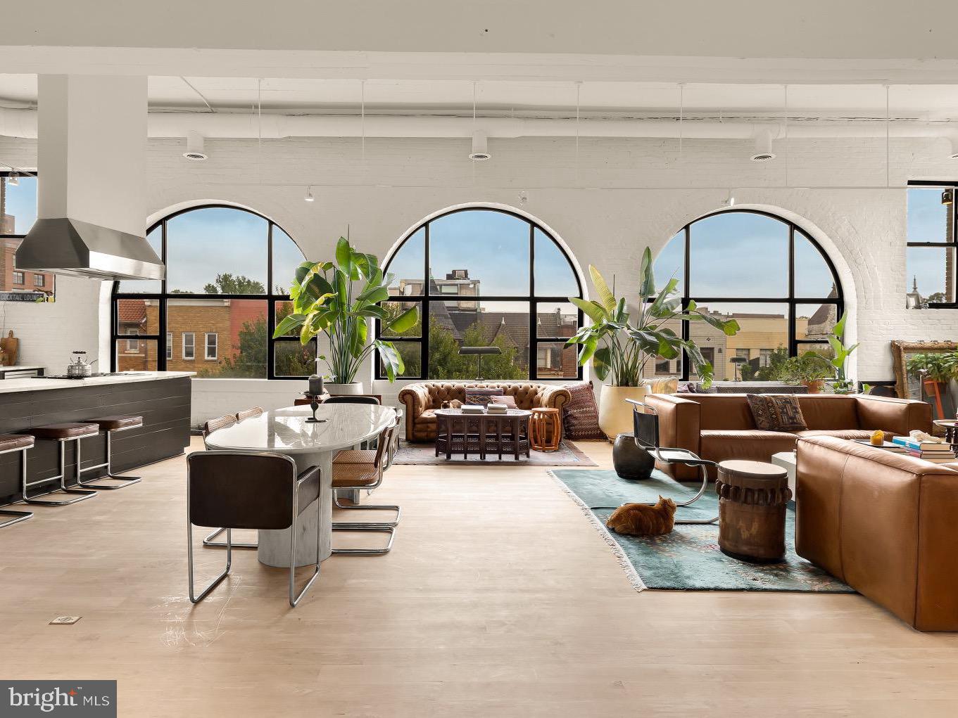 a living room with couches a fireplace and a large window