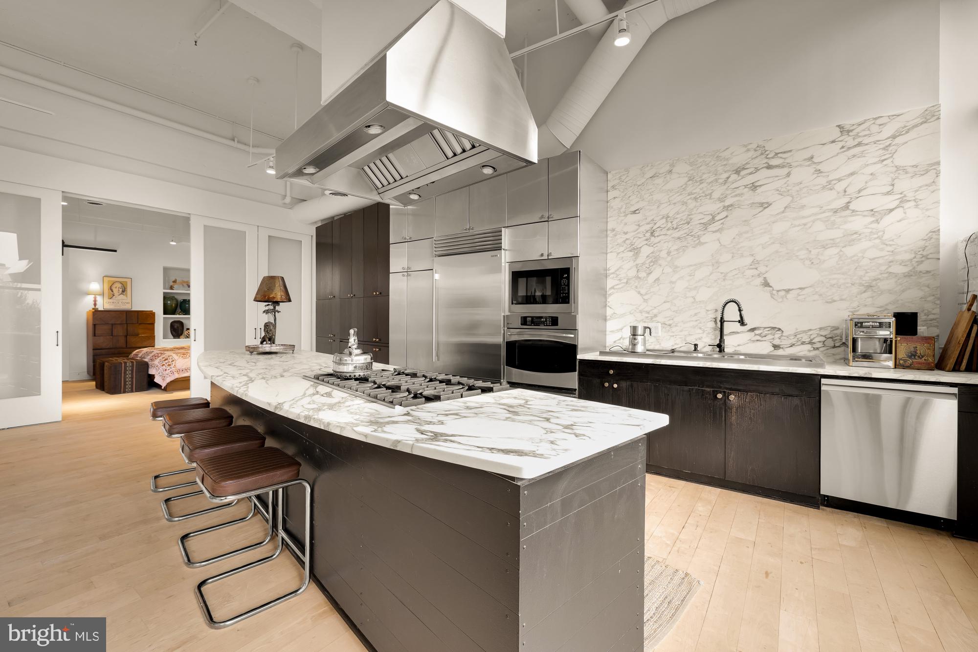 2424 18th Street Northwest, Unit R1 Washington, DC 20009 - Photo 13 of 24 a kitchen with stainless steel appliances kitchen island granite countertop a sink and cabinets
