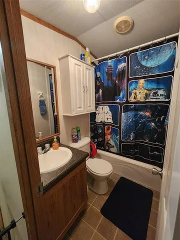 a bathroom with a sink vanity mirror and toilet
