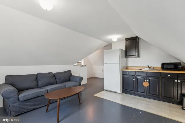 a living room with furniture a refrigerator and a table