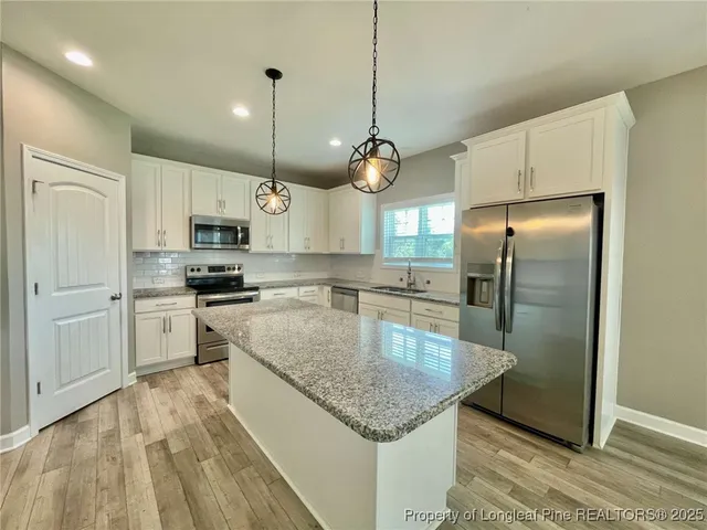 a kitchen with kitchen island a counter top space stainless steel appliances and cabinets