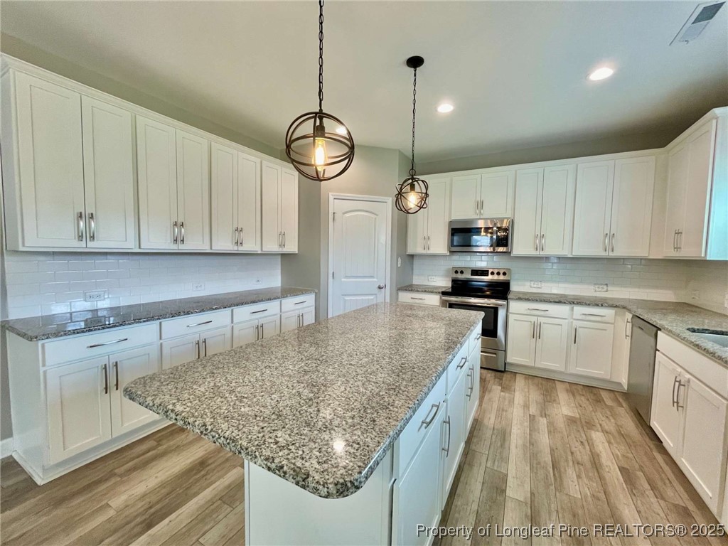 356 Kensington Drive Spring Lake, NC 28390 - Photo 19 of 28 a kitchen with stainless steel appliances granite countertop a sink dishwasher a stove and white cabinets
