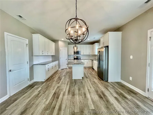 a kitchen with stainless steel appliances granite countertop a refrigerator a stove and a sink