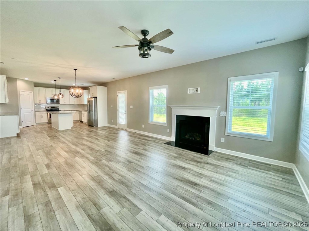 356 Kensington Drive Spring Lake, NC 28390 - Photo 22 of 28 a view of a livingroom with a fireplace a ceiling fan and wooden floor