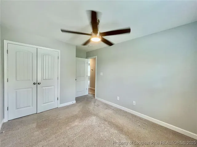 an empty room with closet and a chandelier fan