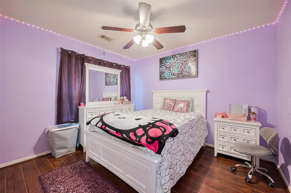 a bedroom with a bed a chandelier and a dresser