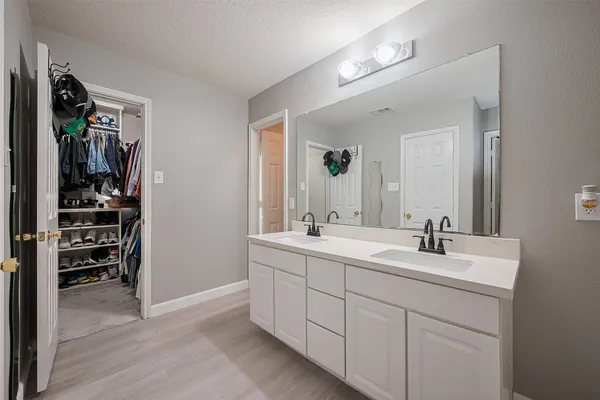 a bathroom with a double vanity sink and a mirror