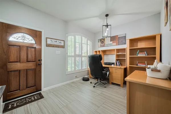 a view of a workspace with furniture and a window