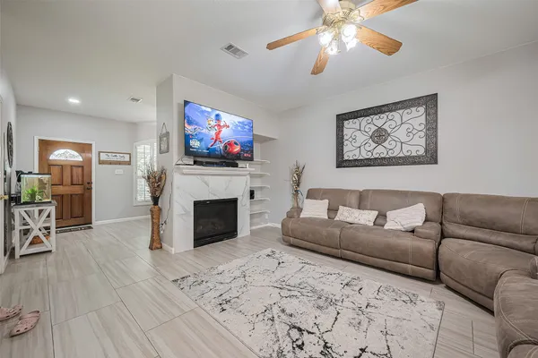 a living room with furniture a flat screen tv and a fireplace