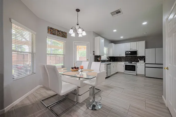 a view of a dining room and livingroom with furniture wooden floor a chandelier