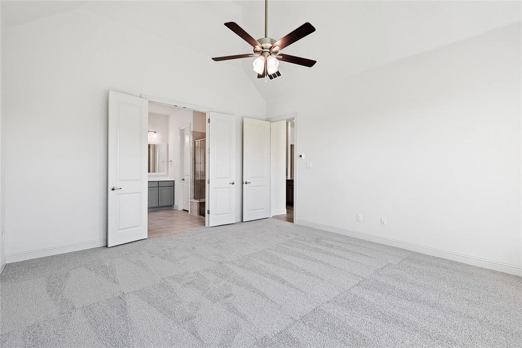 313 Trinity Court Shady Shores, TX 76208 - Photo 13 of 24 Unfurnished bedroom featuring high vaulted ceiling, light carpet, ceiling fan, and ensuite bath