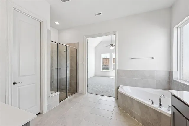 a bathroom with a tub sink and mirror