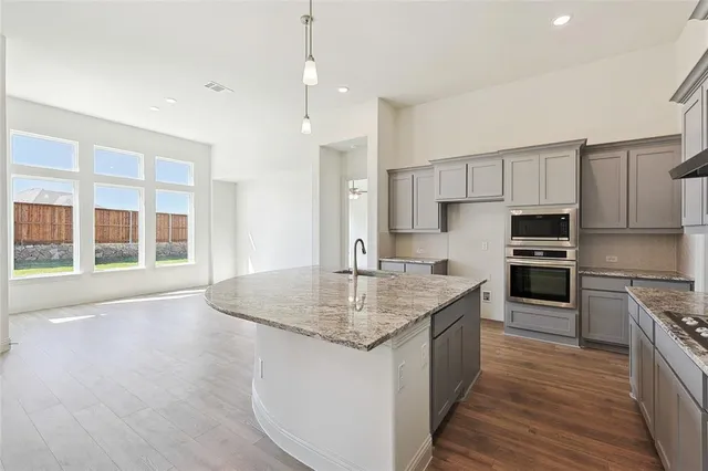 a kitchen with stainless steel appliances granite countertop a sink stove and refrigerator