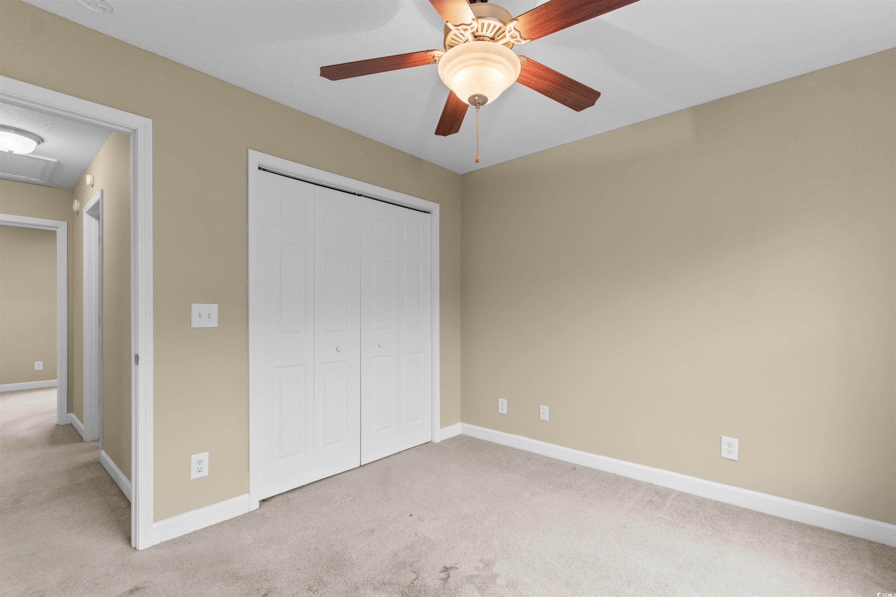 85 Graham Road Georgetown, SC 29440 - Photo 21 of 39 Unfurnished bedroom with light carpet, a ceiling fan, a closet, and attic access