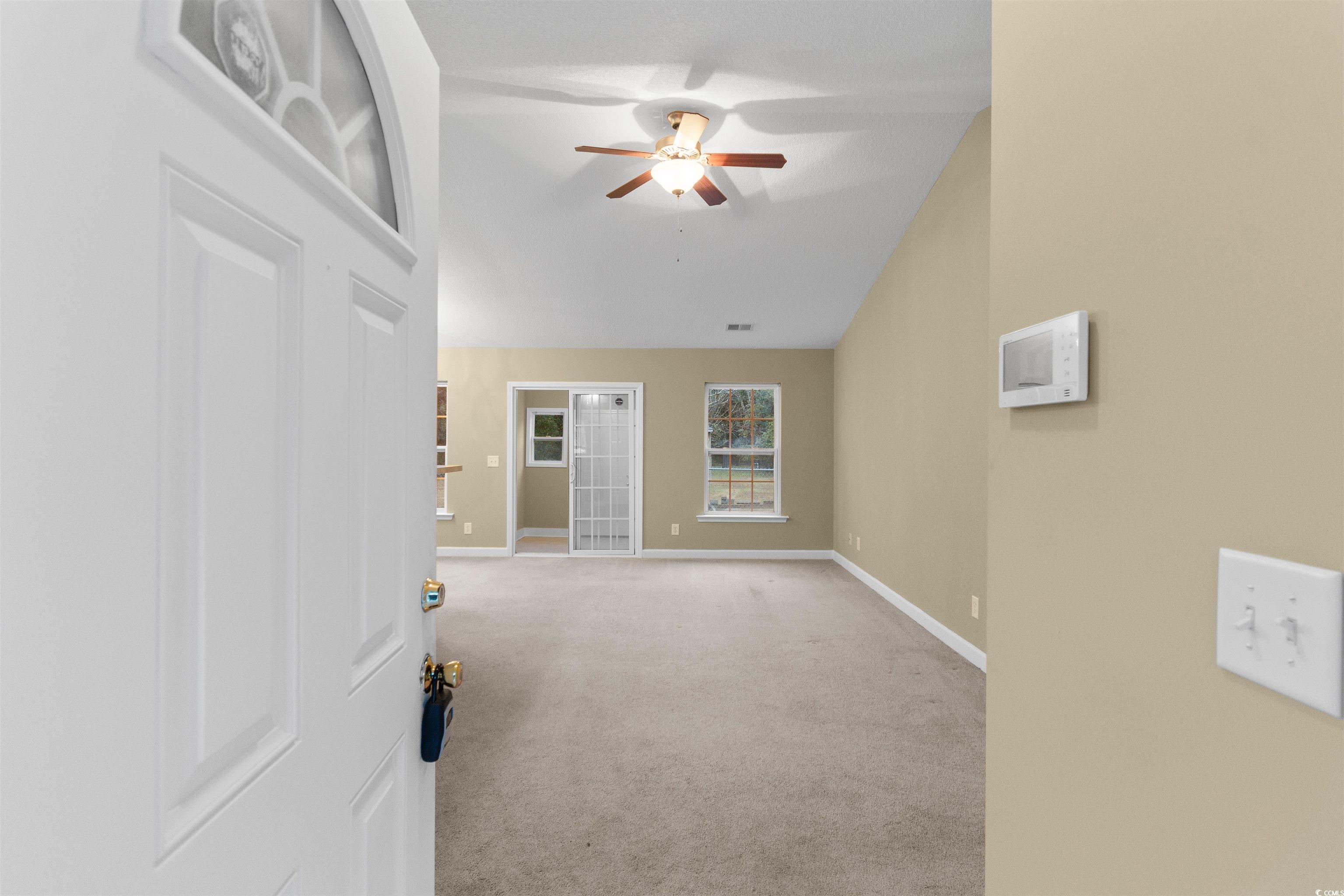 85 Graham Road Georgetown, SC 29440 - Photo 3 of 39 Spare room featuring lofted ceiling, light colored carpet, and a ceiling fan