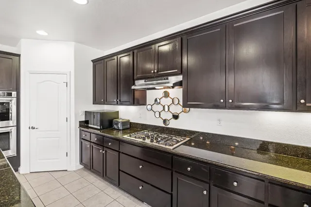 a kitchen with granite countertop stainless steel appliances and cabinets counter space