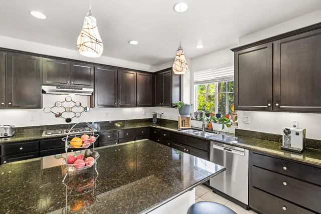 a kitchen with stainless steel appliances granite countertop a sink stove and cabinets