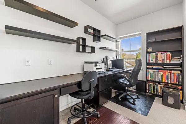 a view of a workspace with furniture and a book shelf