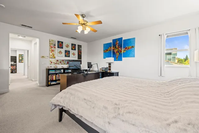 a bed room with a bed and painting on the wall