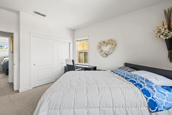 a bedroom with a large bed and a window