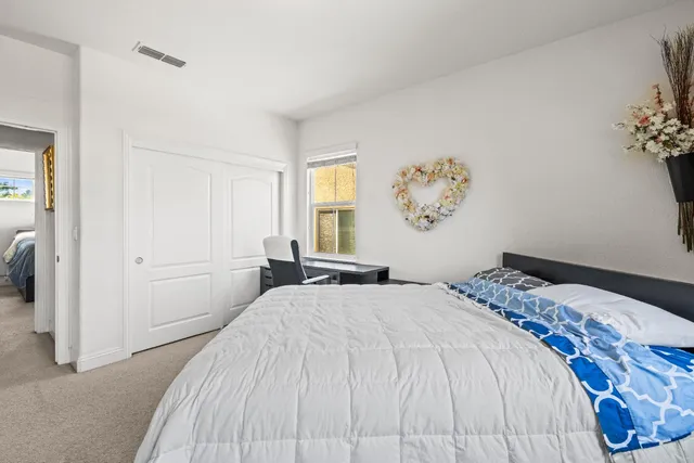 a bedroom with a large bed and a window