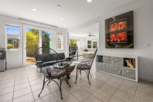 a living room with furniture a flat screen tv and floor to ceiling window