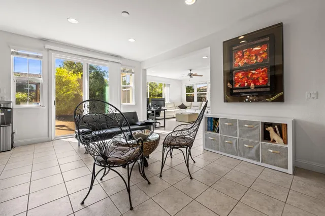 a living room with furniture a flat screen tv and floor to ceiling window