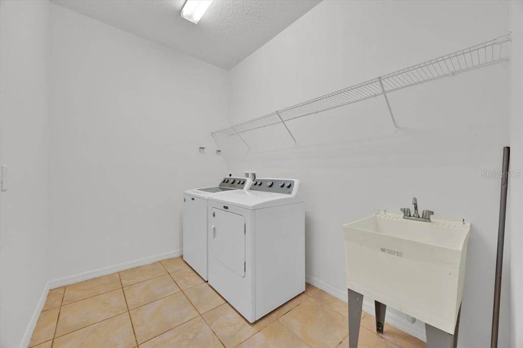 8755 Rindge Road Polk City, FL 33868 - Photo 16 of 25 a utility room with cabinets washer and dryer