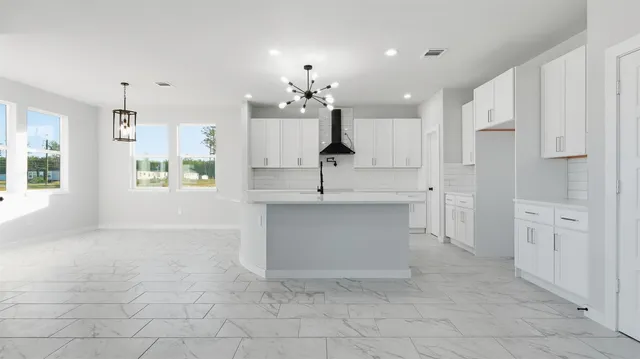 a view of kitchen with white cabinets and sink