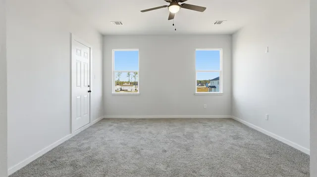 an empty room with windows and closet