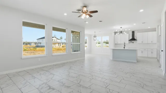 a view of an empty room and a kitchen