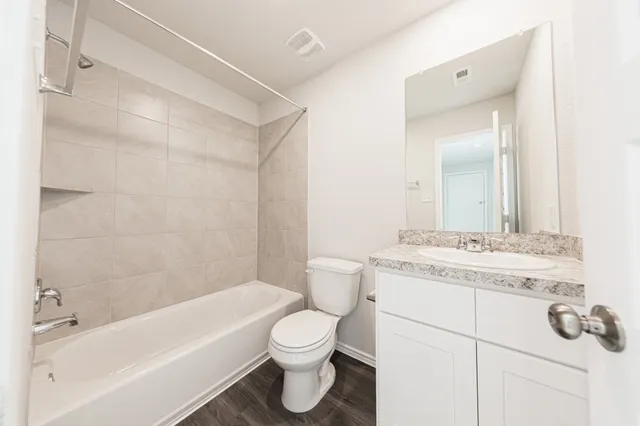 a bathroom with a granite countertop sink a toilet and bathtub