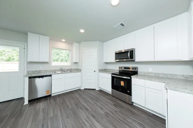 a kitchen with granite countertop white cabinets and white appliances