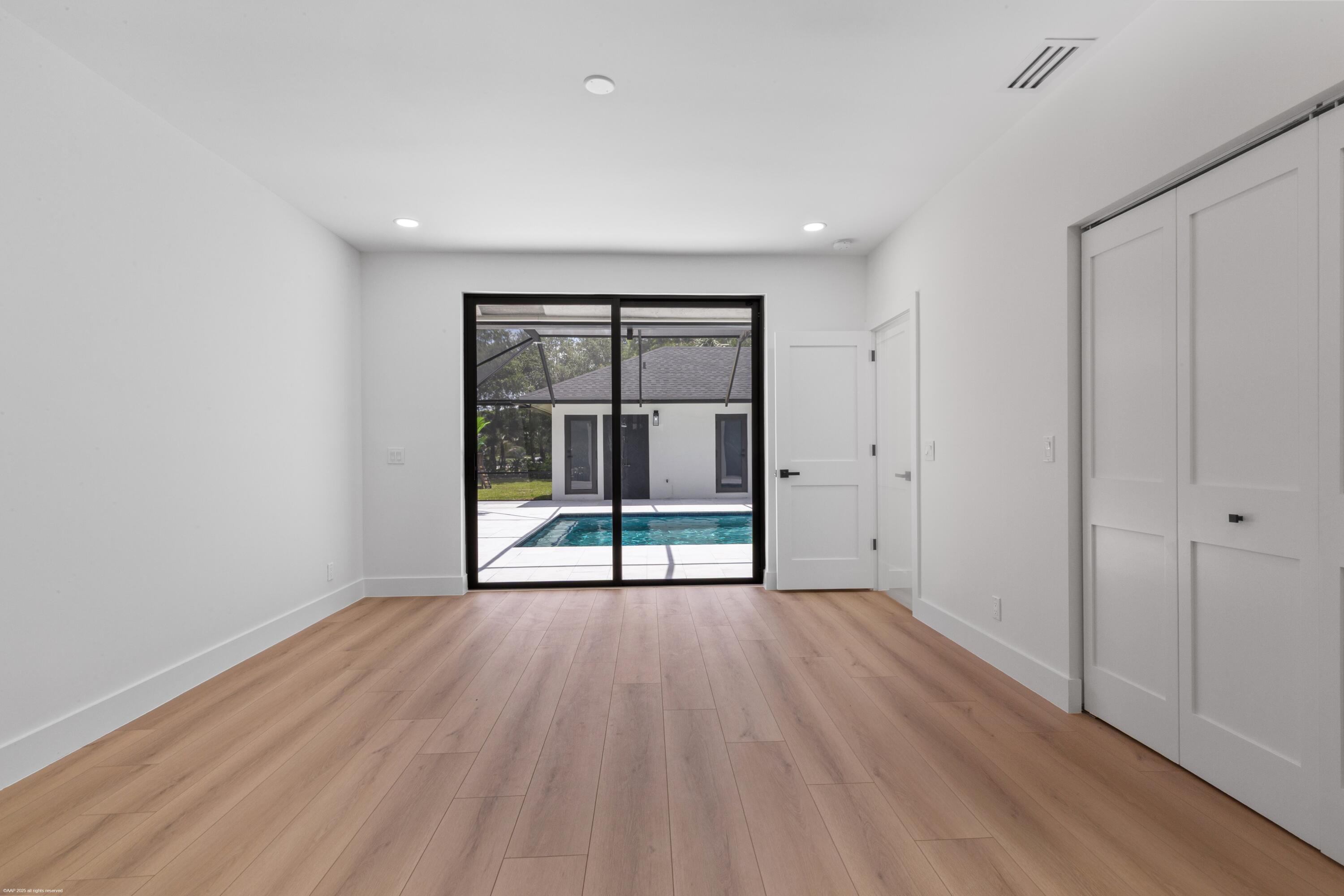 13453 Doubletree Trail Wellington, FL 33414 - Photo 46 of 65 a view of an empty room with wooden floor and a window