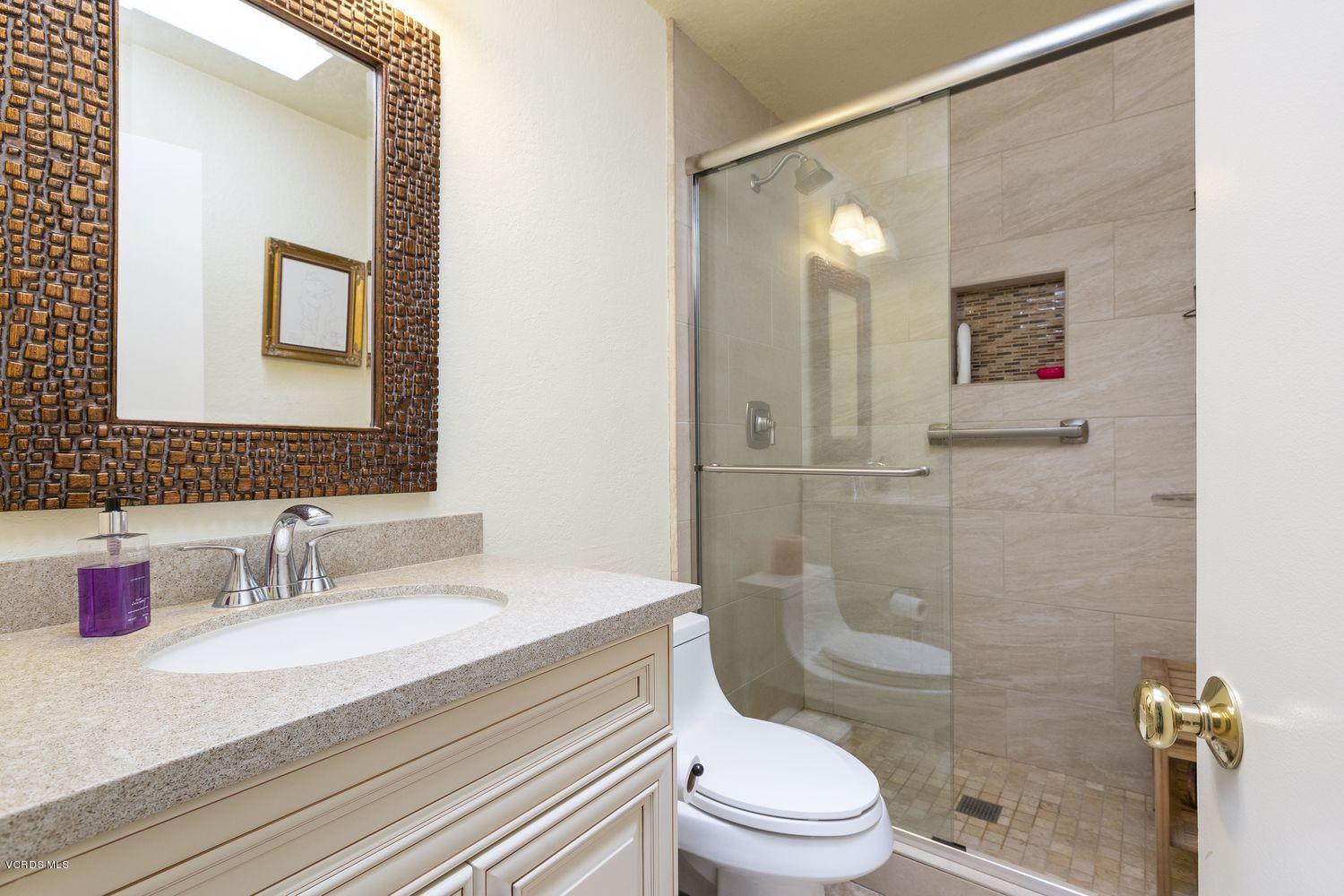 1411 Kelp Street Oxnard, CA 93035 - Photo 16 of 24 a bathroom with a granite countertop sink toilet a mirror and shower