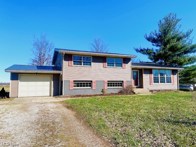 Tri-level home with a front lawn and a garage