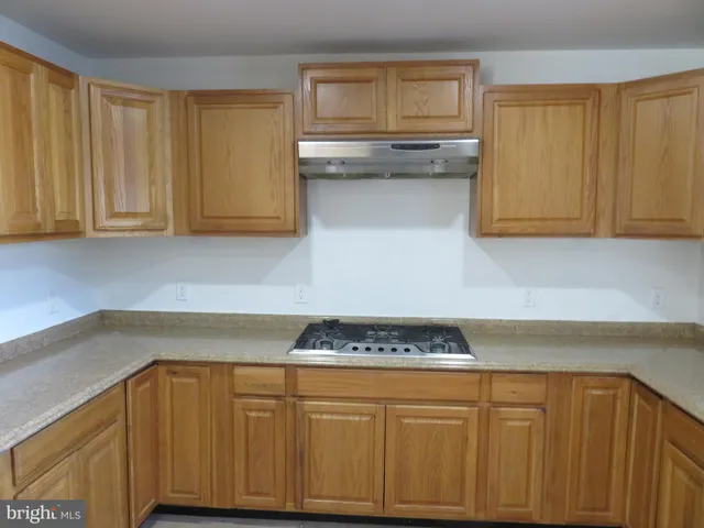 a kitchen with stainless steel appliances kitchen island granite countertop a refrigerator and a sink