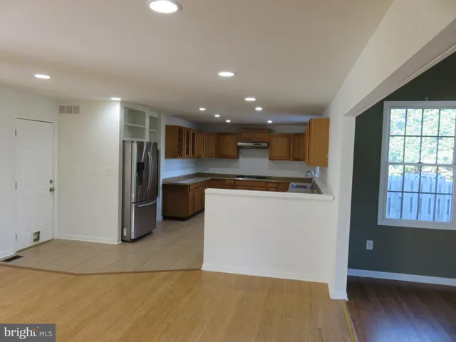 a view of an empty room with wooden floor and windows