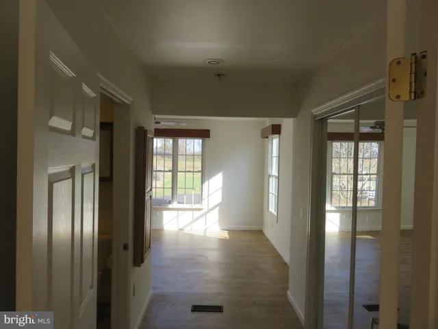 an empty room with a window and a ceiling fan