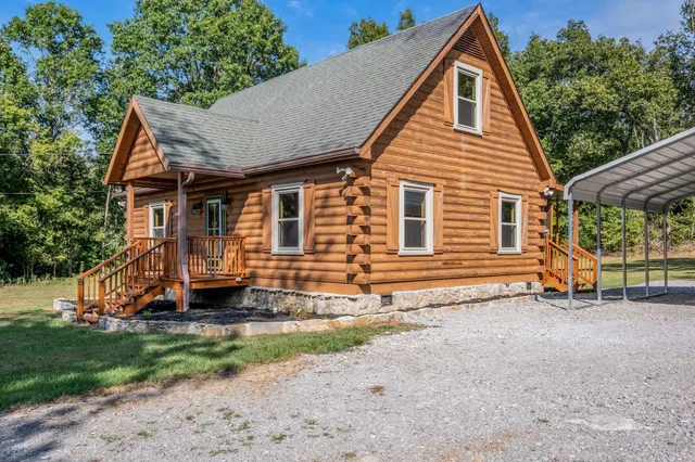 a view of a house with a yard and lawn chairs