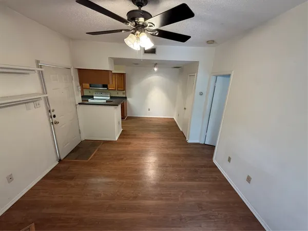 a view of a kitchen with wooden floor and a ceiling fan