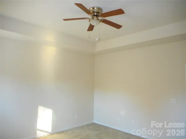 an empty room with a window and a ceiling fan