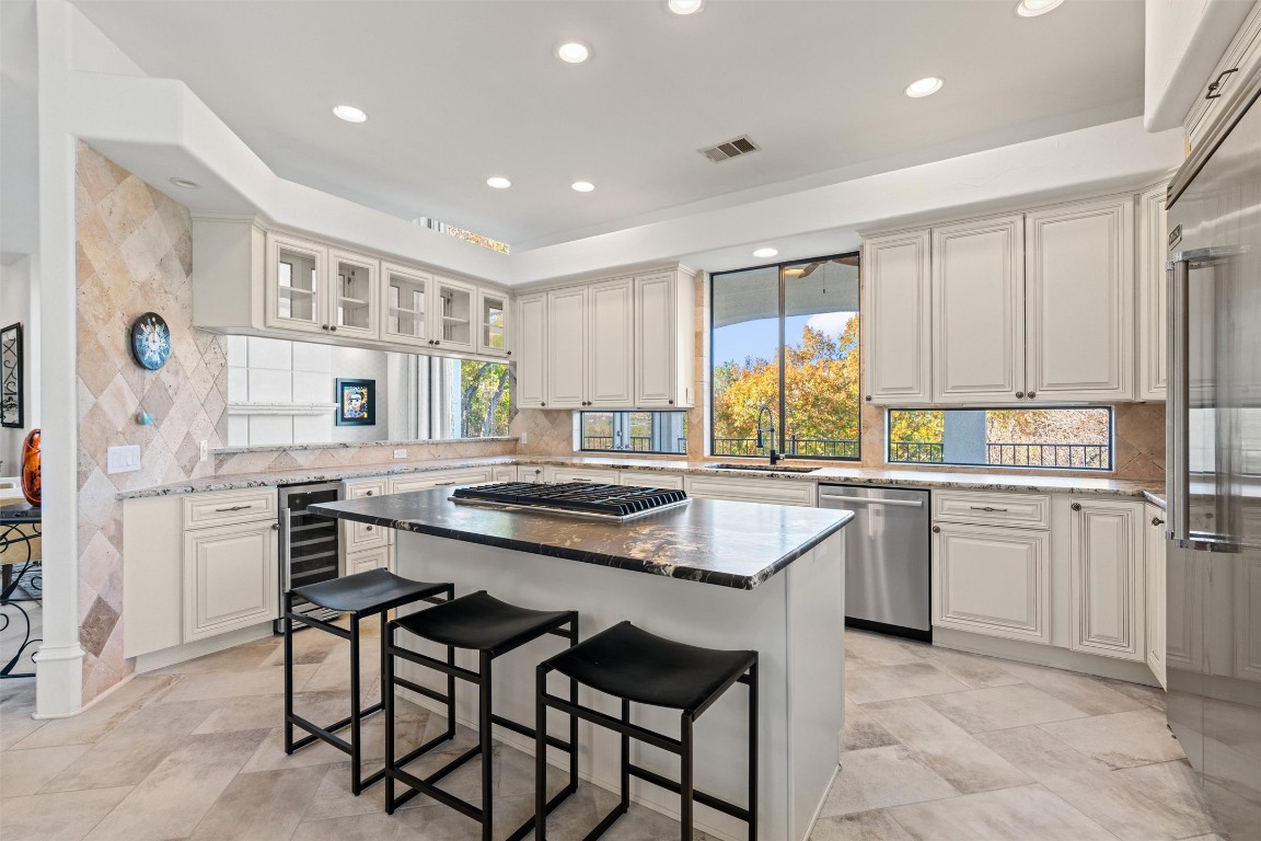 5706 Long Court Austin, TX 78730 - Photo 16 of 40 a kitchen with stainless steel appliances granite countertop a stove and white cabinets
